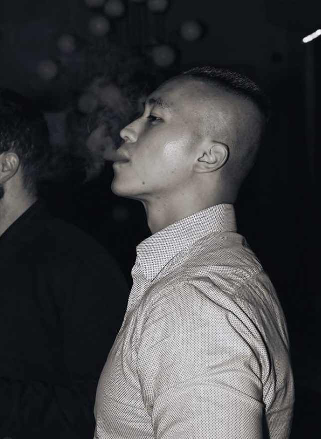 Black and white profile of a member exhaling smoke