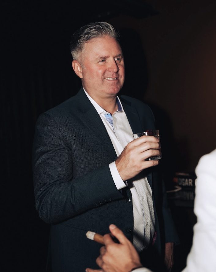 A member with a drink at an evening gathering