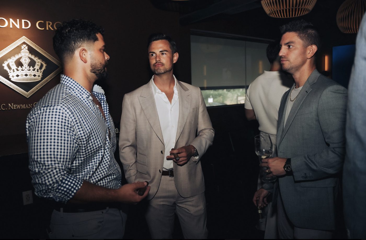 Three members talking beneath the Diamond Crown crest
