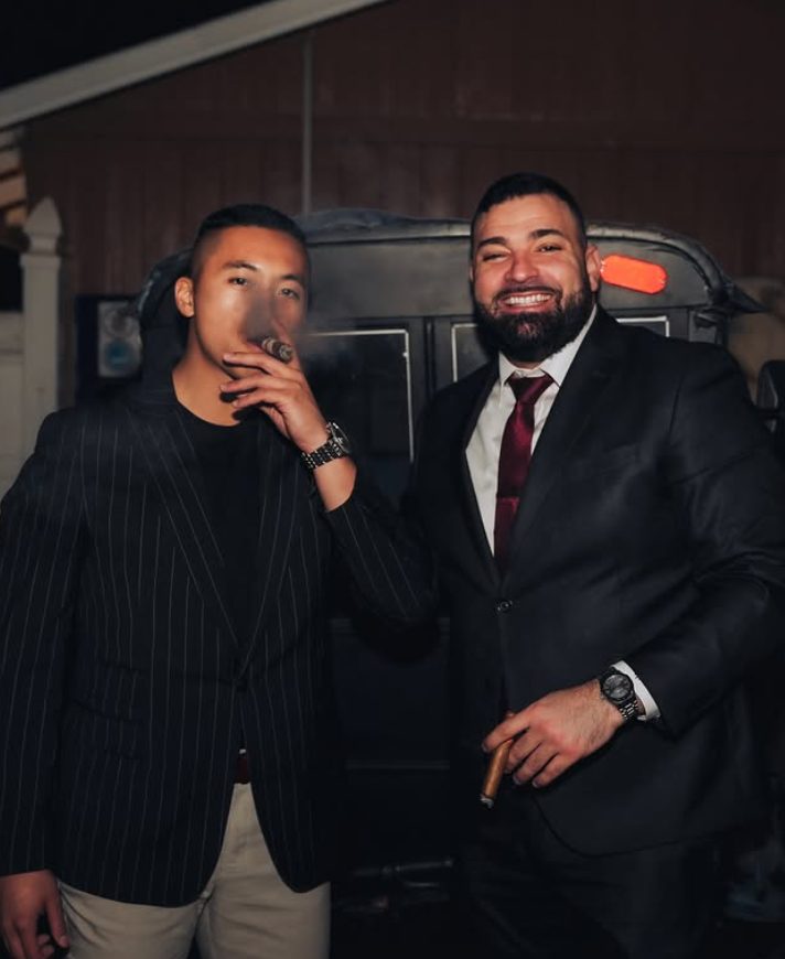Two members with cigars at an evening gathering
